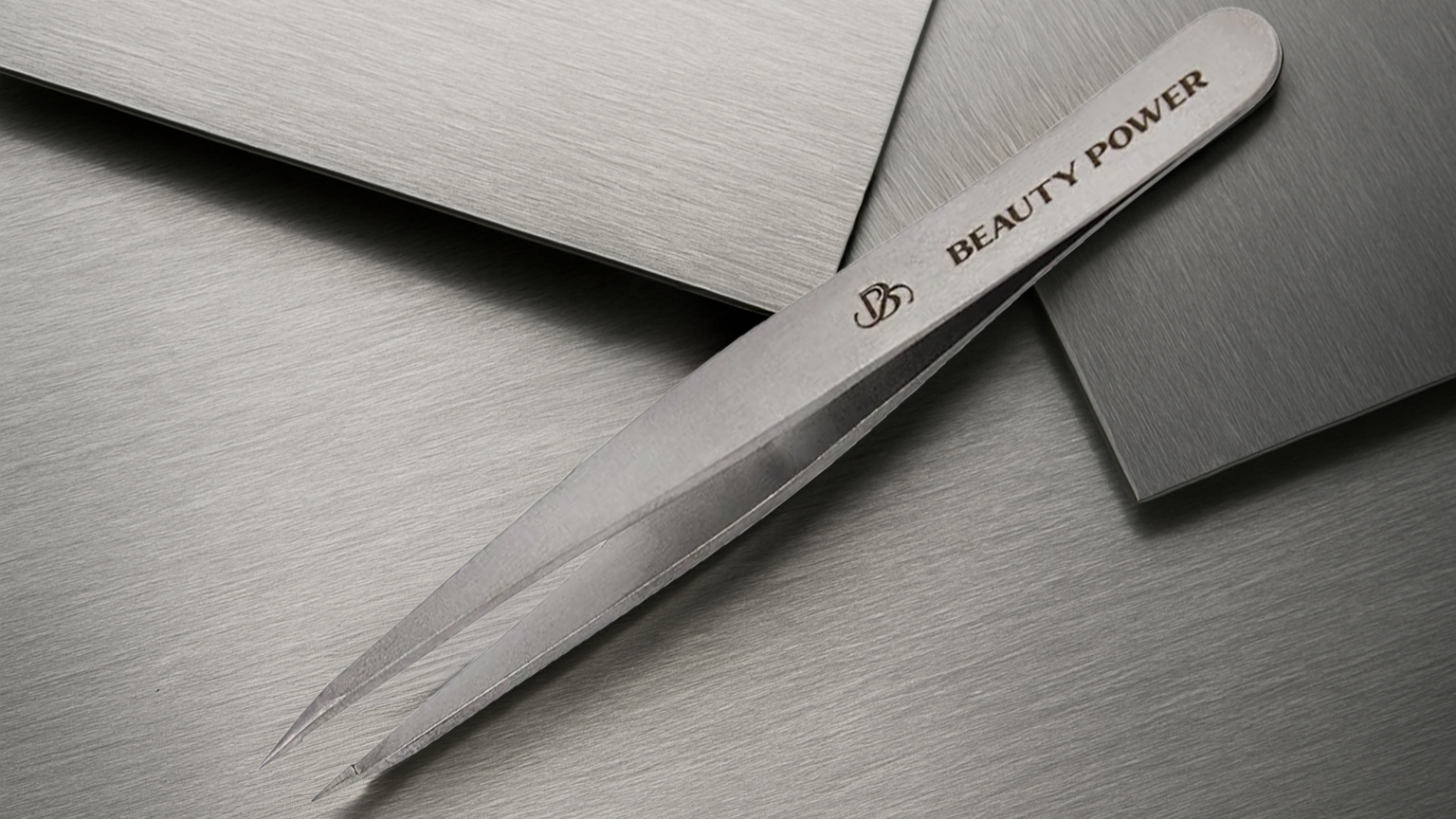 Stainless steel tweezers with 'Beauty Power' branding on a metallic surface