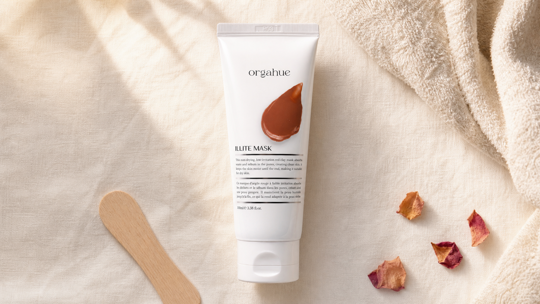 Orgahue Illite Clay Mask tube on cream linen, Beauty Power editorial flat lay