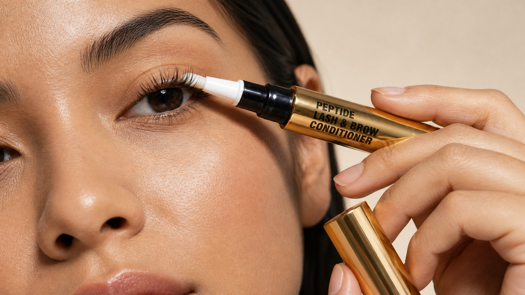 Beauty Power Peptide Lash Serum applied along the upper lash line with gold tube product in frame