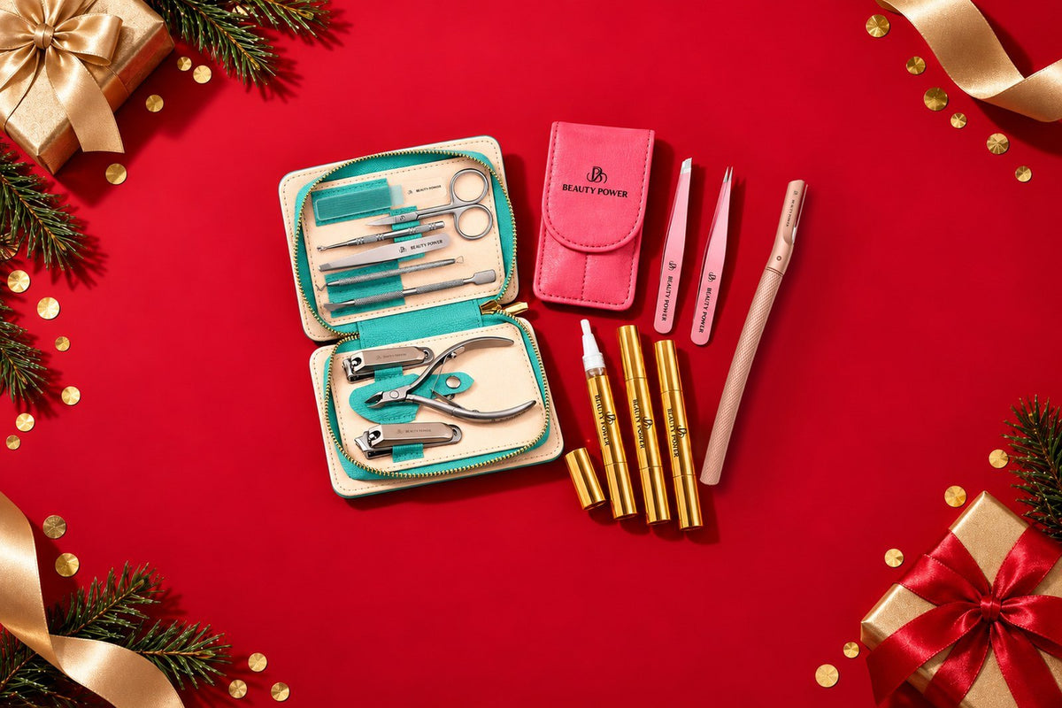 Beauty Power holiday gifts: rose gold eyebrow razor, pink slant and point tweezers set, cuticle oil pens and 9-in-1 manicure set on red background